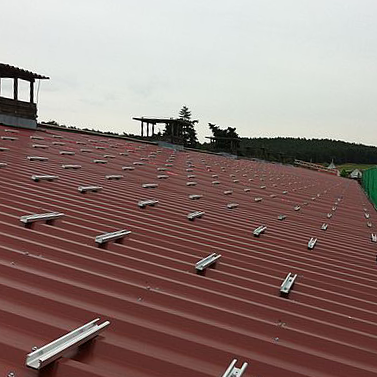 Rotes Wellblechdach mit Unterkonstruktion in Vorbereitung für die Solarmodule.