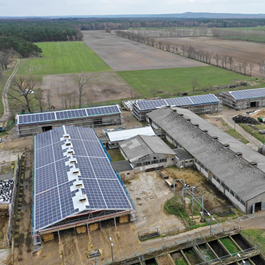 Zwei Hallen während des Bauprozesses aus der Luft fotografiert. Erste Halle ist mit Photovoltaik auf dem Dach bestückt.