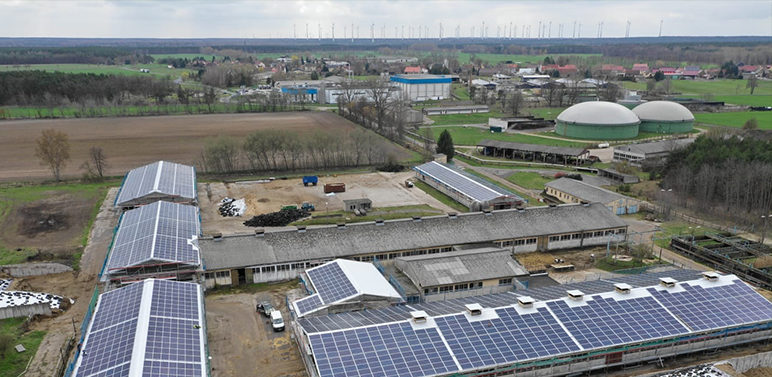 Luftbildaufnahme mehrerer großer Hallen von einem Landwirtschaftsbetrieb bestückt mit Photovoltaik.