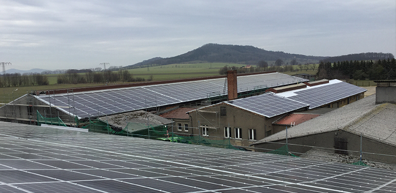 Übersicht vom Dach aus auf 3 Hallen die mit Photovoltaikmodulen bestückt sind.